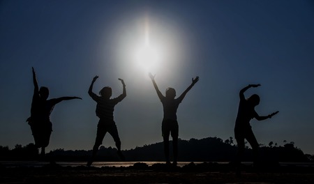 Four people jumping at the seaside ,silhouette Image