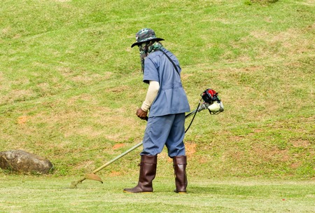 gardener cutting grass by lawn mower.worker cutting grass