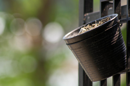 Empty flower pot hung on a steel grateの写真素材