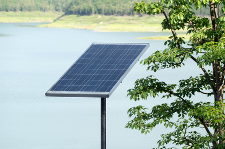 Solar cell panel near the dam. Solar energy concept and treeの写真素材