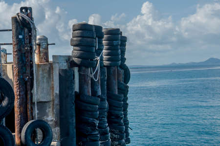 Rubber tyre used as a safety buffer for boats parking to the harbor , old tiresの写真素材