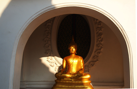 Gold statue buddha sitting in the temple terraceの写真素材