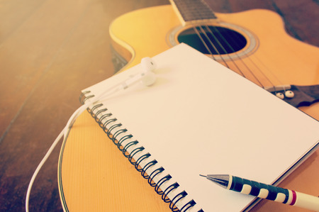 Notebook and wooden pencil on guitar,Writing music filtered effectの写真素材