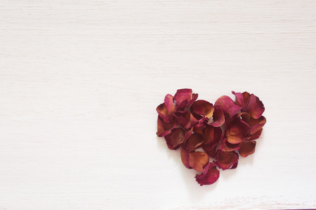 Dried rose heart shape lay on whte wooden backgroundの写真素材