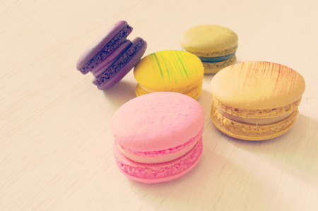 colorful macarons lay on wooden background retro effect imageの写真素材