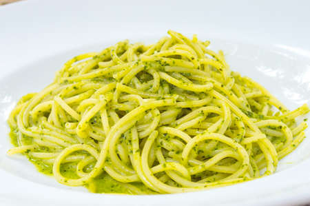 Spaghetti with pesto sauce in white plateの写真素材