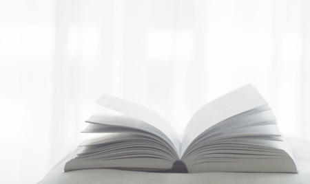 Open book on a pillow in bed. life in homeの写真素材