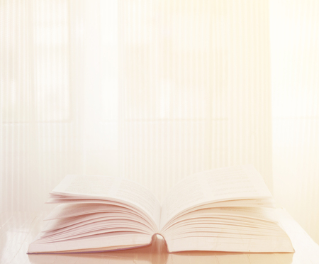 Open book on wood background with sunlight retro effect imageの写真素材