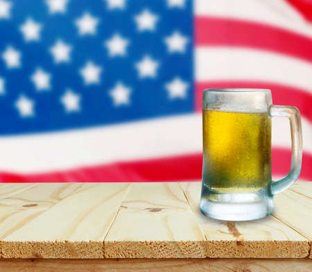 Glass of beer on wooden table. USA flag background celebrate American Independence Day of 4th Julyの写真素材