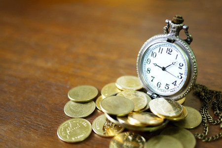 vintage golden pocket watch with stack  on wood table background.time money concept.