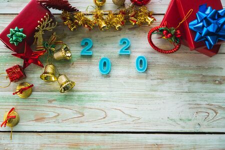 Here are Christmas tree decorations and many bright red gift boxes. Placed on a beautiful wooden...