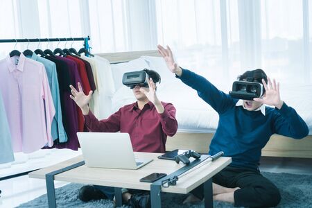 Two Asian men are having fun reviewing and selling products via live media via social media.の写真素材