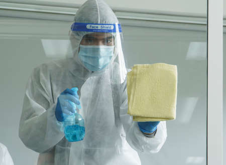 Workers wear protective clothing and wear a mask. Spraying disinfectants for cleaning inside the building. Cleaning service professionals are becoming popular After the spread of coronavirusの写真素材