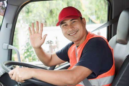 Professional worker truck driver, confident middle-aged Asian man wearing safety clothing Smile...
