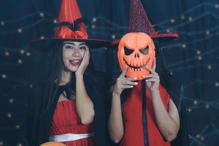 Beautiful Caucasian women and friends dressed up in Halloween witch costumes. Attractive young woman...