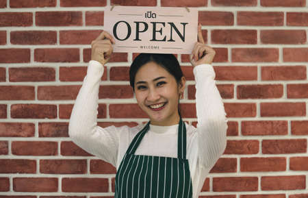 Attractive young Asian women smiling and confident in cafe. young female barista, owner coffee shop,...