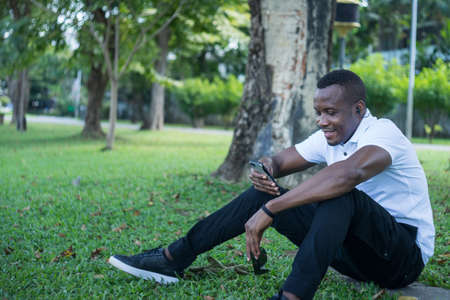 portrait muscular young male relaxing in green forest park. African American young businessman in...