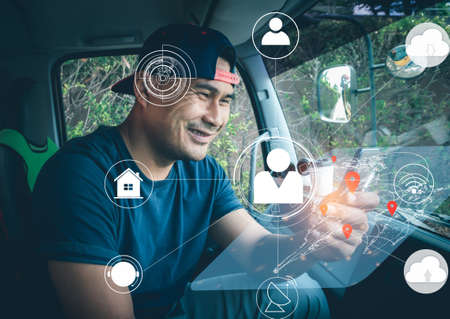 Truck driver man using modern high tech technology digital. Worker deliver men communication with people online. Young Asian men connection network and find their location on the world map screen.の写真素材