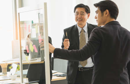 business people in a black suit talking discussion present marketing plan mature executives in meeting seminar in modern office. male and female lawyer planning document management at the law firm.の写真素材