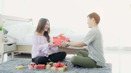 Romantic Gift. young Asian couple Giving Wrapped Box To each other celebrating Holiday Together...