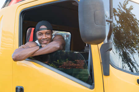 truck driver smiling confident in insurance cargo lorry In long transportation and delivery business. young African-American man training driving commercial driver license at truck driving school.の写真素材