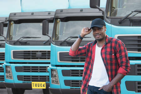portrait African male happy Smiling confident positive near lorry. Young Man plaid shirt owner Truck Driver In Business Long transport thumbs up satisfied service commercial driving license training.の写真素材