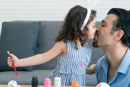 Happy family funny smiling and laughing, Little daughter playful and wearing bunny ears kissing...