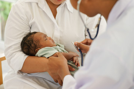 A newborn baby boy one-month-old mixed-race African-Thai,  visiting the doctor for checkup health with stethoscope at the clinic pediatric. concept consultation, check-up, nurse, healing infant.の写真素材