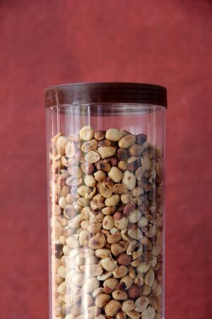 Roasted peanuts in plastic jarの写真素材