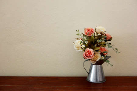 Watering can filled with rosesの写真素材