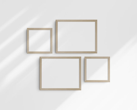 Four wooden frames on a white wall with shadows. Clean, simple, and modern frame mockup. Wall art mockup. Gallery wall mockup.の写真素材
