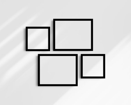 Set of four black photo frames on a white wall with shadows. Clean, modern, and minimalist gallery wall mockup. Frame mockup. Wall art mockup.の写真素材