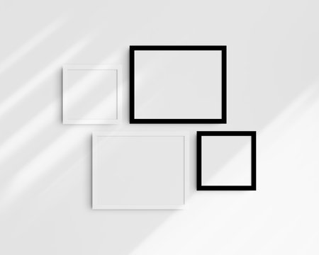 Four black and white frames on a white wall with shadows. Frame mockup.の写真素材