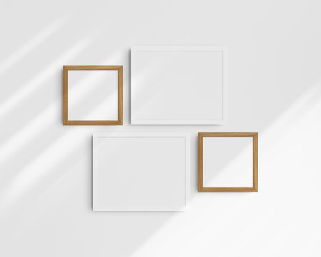 Four blank photo frames on a white wall with shadows. Clean, modern, and minimalist gallery wall mockup. Frame mockup set.の写真素材