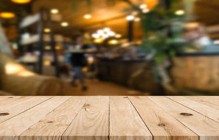 Empty top wooden table with blurred in coffee shop backgroundの写真素材
