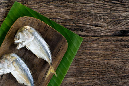 Steamed Mackerel on cutting board with banana leaf background. Top view with copy spaceの写真素材
