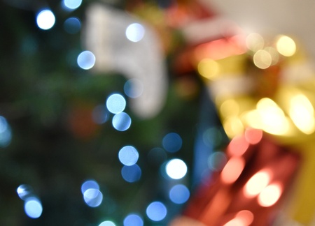 Bokeh mode of Christmas pine tree decorated with light and present box beside
