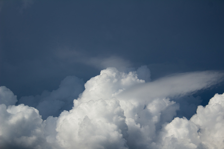 white cumulus clouds on dark blue sky before the stormの写真素材