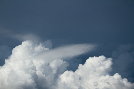 white cumulus clouds on dark blue sky before the stormの写真素材