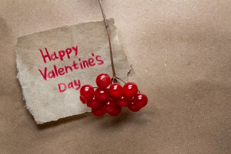 Happy Valentine's Day card handmade with heart and red viburnum on the background of kraft paperの写真素材