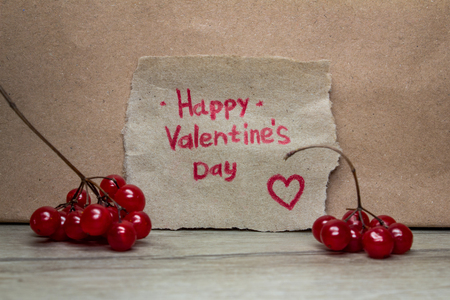 Happy Valentine's Day card handmade with heart and red viburnum on the background of kraft paperの写真素材