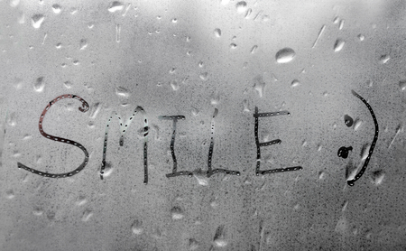 Handmade word smile on the wet glass windowの写真素材