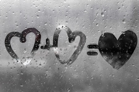 two hearts with plus sing and equality sign on window in Rainy weather , valentine's day , day valentineの写真素材