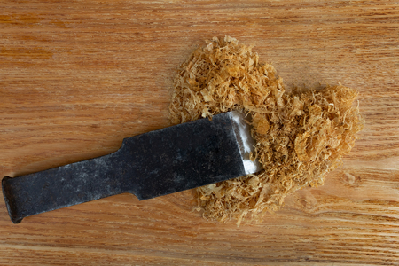heap of sawdust in the shape of a heart and a cleaver lie on a wooden backgroundの写真素材