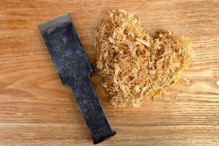 heap of sawdust in the shape of a heart and a cleaver lie on a wooden backgroundの写真素材