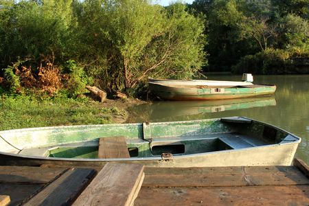 wooden old green boats early in the morning at the boat station in Georgia by the riverの写真素材
