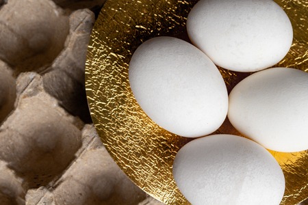 Easter white eggs on gold background egg packaging . Holiday background