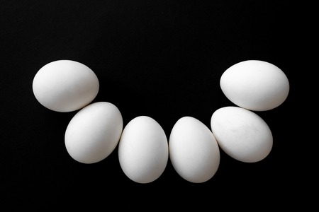 six white chicken eggs beside on a wooden background. Easter concept