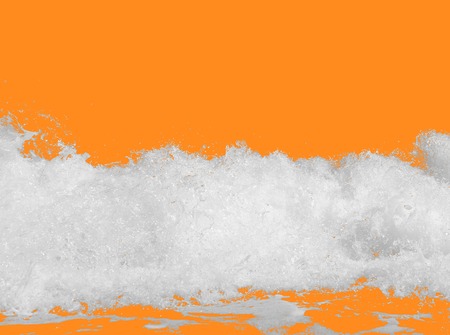 white sea foam from the surf, isolated on a bright orange background, the concept of summer vacations, travel, relaxing on the seashore, place for textの写真素材