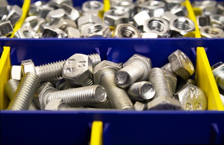 shiny new bolts and nuts in a container, close-upの写真素材